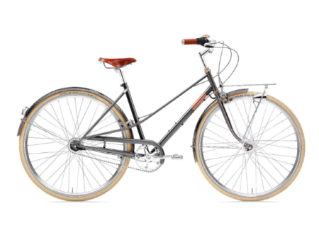 Un creme cycles caferacer stationné sur une place urbaine mettant en avant les finitions classiques du cadre acier.