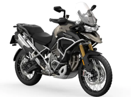 Triumph Tiger 1200 Explorer 2026 grise stationnée sur route avec valises latérales et design touring premium.