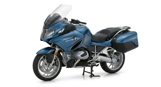 Moto bmw r 1250 rt noire stationnée sur route avec valises latérales et design touring premium.