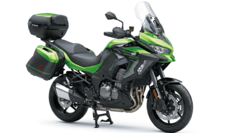 Moto kawasaki versys 1100 se verte et noire stationnée sur route avec équipement touring et design moderne.