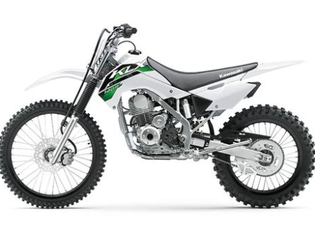 Moto kawasaki klx 140 verte et noire stationnée sur un terrain tout-terrain avec pneus cross et suspension renforcée.