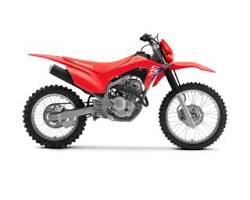 Moto honda crf125f rouge et blanche sur terrain tout-terrain pour pratique du motocross et loisirs off-road.