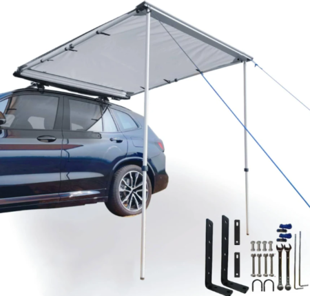 Auvent de véhicule extractible DANCHEL installé sur un véhicule de loisirs créant un espace ombragé et protégé pour le camping.